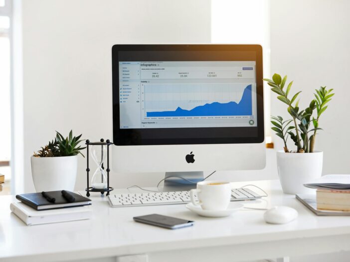 silver imac displaying line graph placed on desk